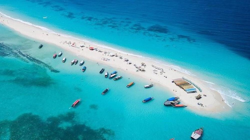 Aerial view of a Zanzibar sandbank with traditional dhows in turquoise water